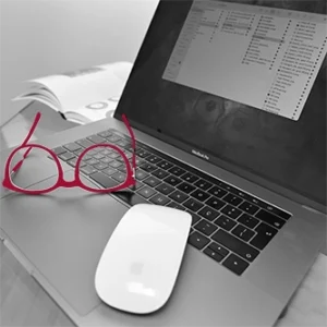 Computador com óculos sobre a mesa, representando o foco e a atenção aos detalhes da RB Creative Studio